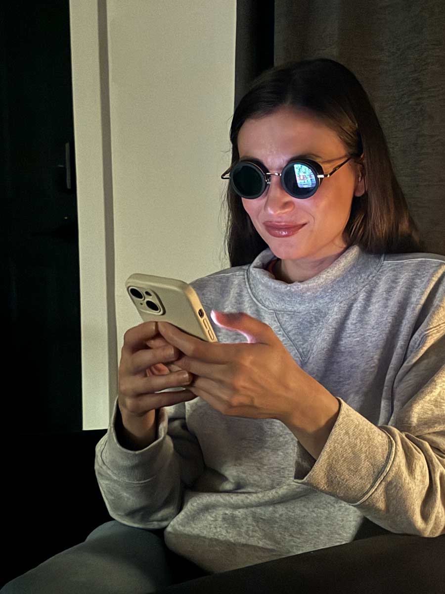 A woman looks at her phone at night