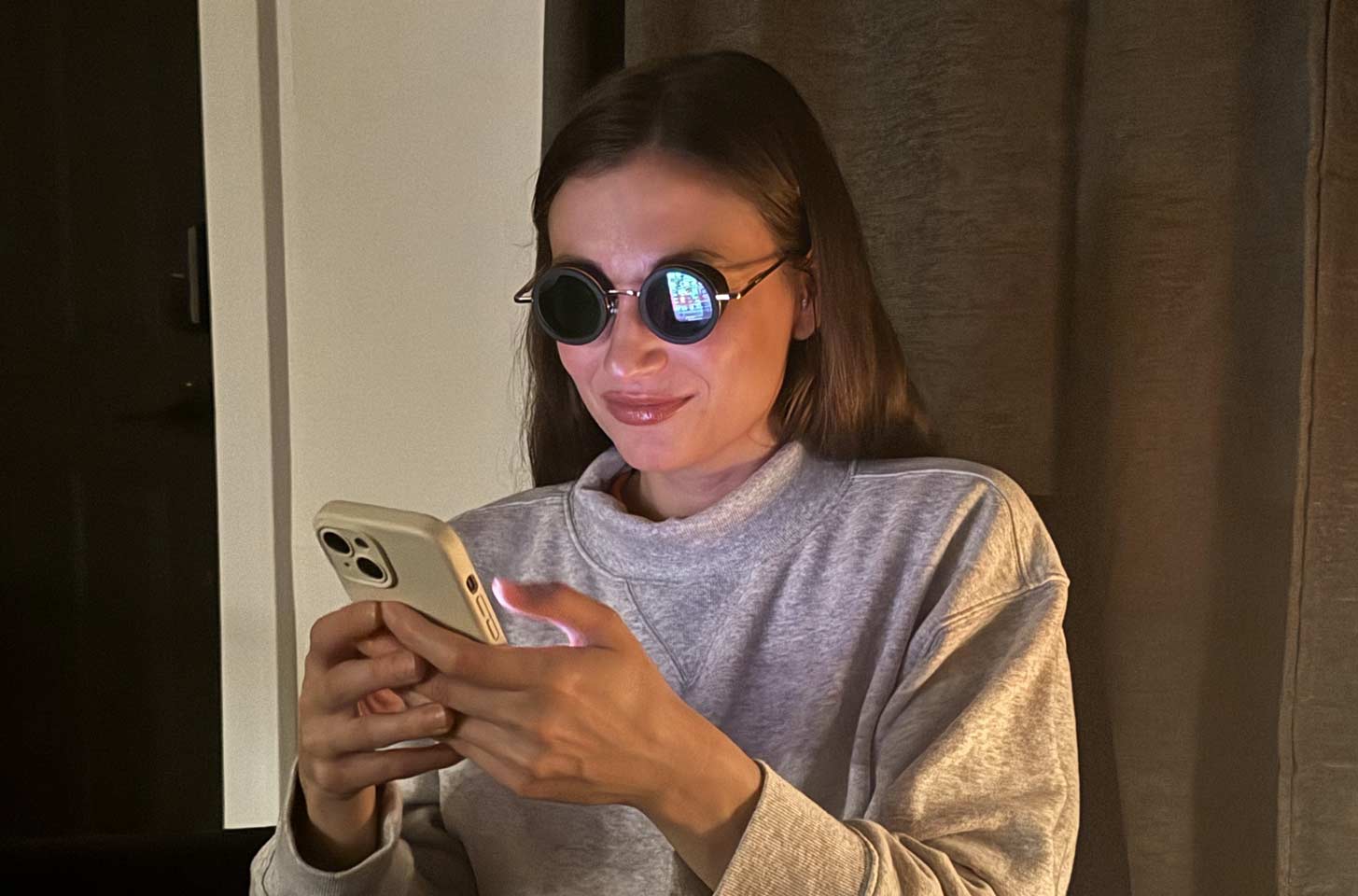 A young woman looks at her phone at night without discomfort.