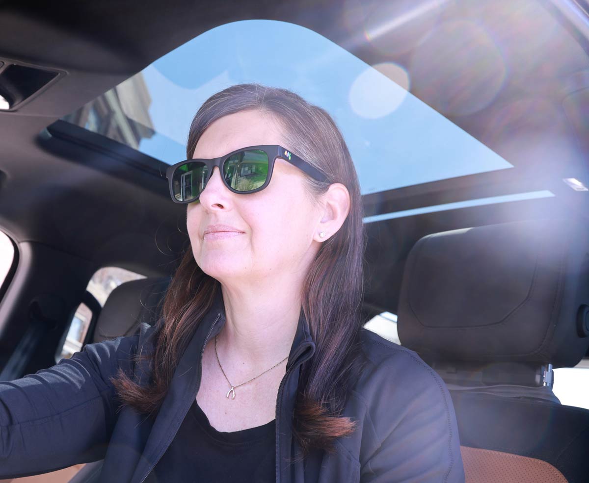 A passenger in a car wearing nbGL glasses to help reduce motion sickness.