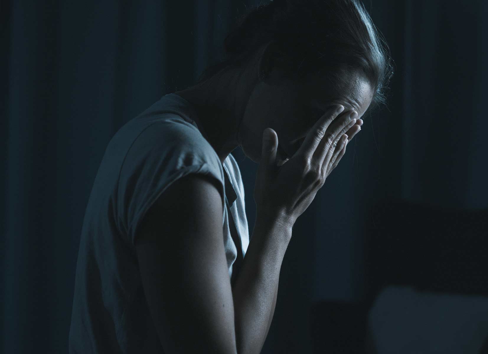 A person experiencing a migraine headache caused by light sensitivity.