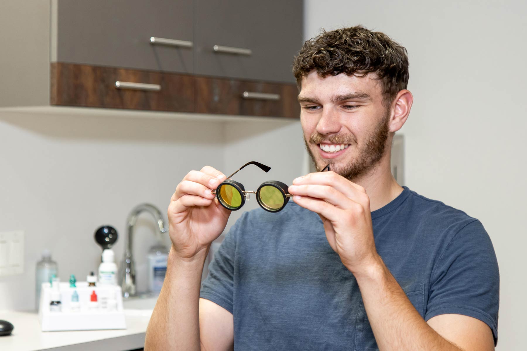 A young man tries therapeutic nbGL glasses for a medical procedure.